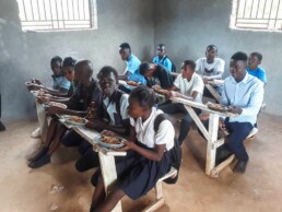Students on La Gonave eating their daily hot meal provided through Starfysh’s school feeding program.