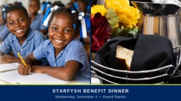 Schoolchildren in a La Gonave classroom beside a table set for dinner. Starfysh Benefit Dinner, Wednesday, November 4, Grand Rapids.